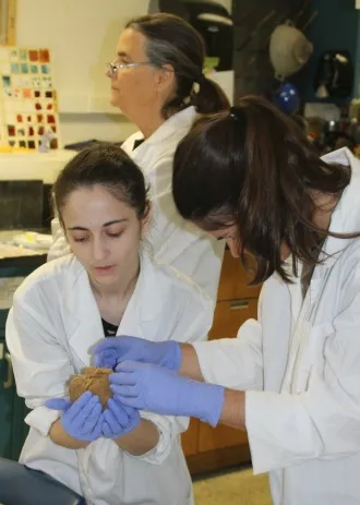 Naomi helping a student with an experiment 