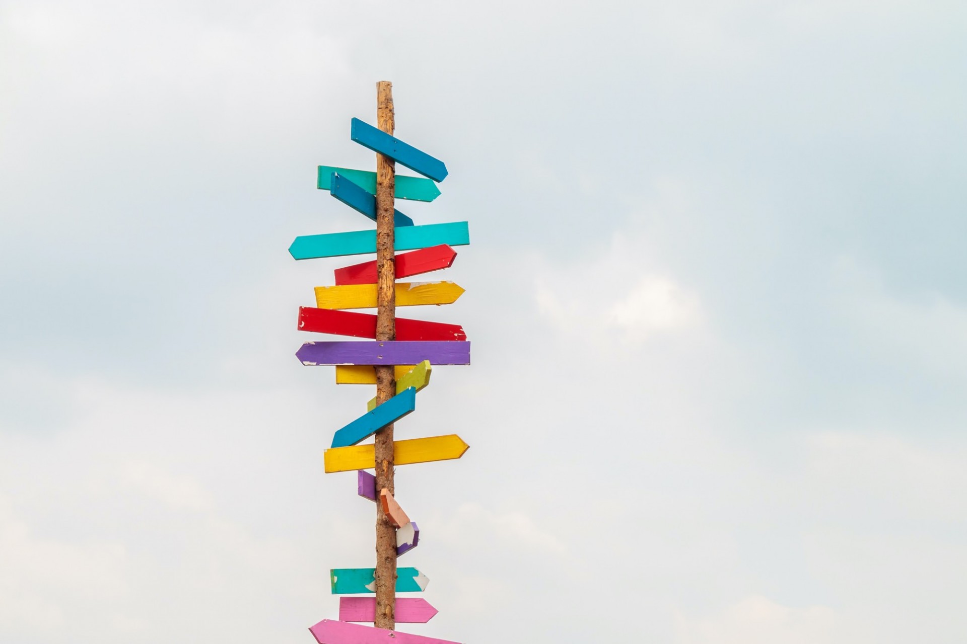 wooden post with attached signs pointing in different directions