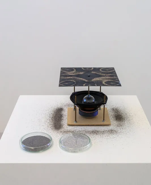 A speaker with an aluminum plate on top of it. 
