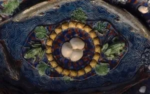 An eye made of clay and muted blue green colors